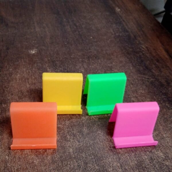 2a2df057-cbc6-4677-acf7-cd6c4007cda2_90a0c26a-46fe-4564-8d77-f314aa3cda84.jpg Durable Plastic Mobile Phone Stand with Angled Support (1 Pc / Mix Color)